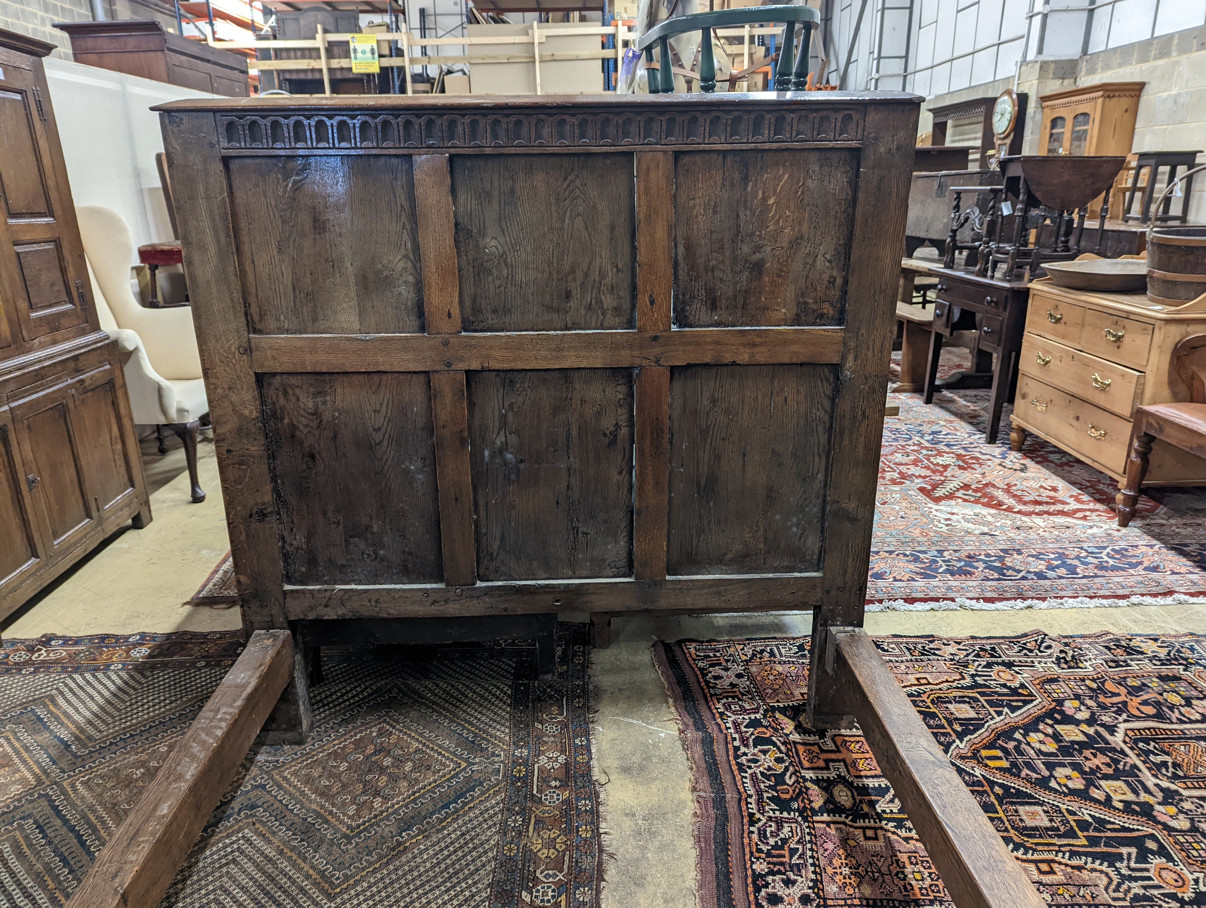 A 17th century style panelled oak bedstead, width 143cm, length 204cm, height 140cm